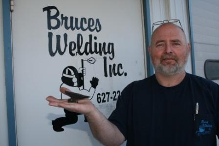 Owner, Bruce Barnes,  holds an anvil which was made for his company's 25th anniversary. 